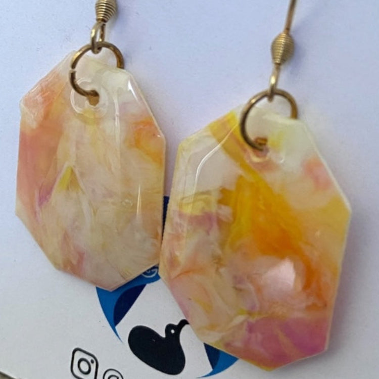 Detailed close-up highlighting the unique marbled surface finish and artisan pink color blend of the recycled plastic geometric earrings.