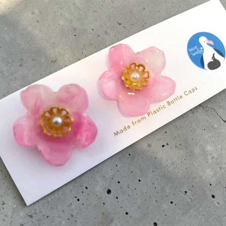 Detailed close-up highlighting the unique marbled texture, 3D petals, and smooth artisan finish of the pink floral recycled plastic studs.