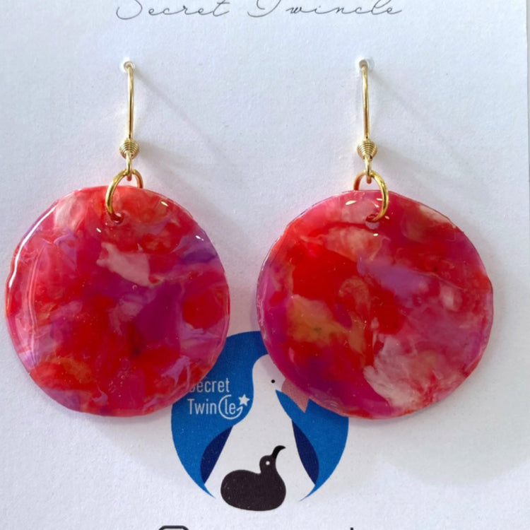 Detailed close-up highlighting the glass-like transparency, smooth edges, and artisan color tones of the recycled plastic circular earrings.