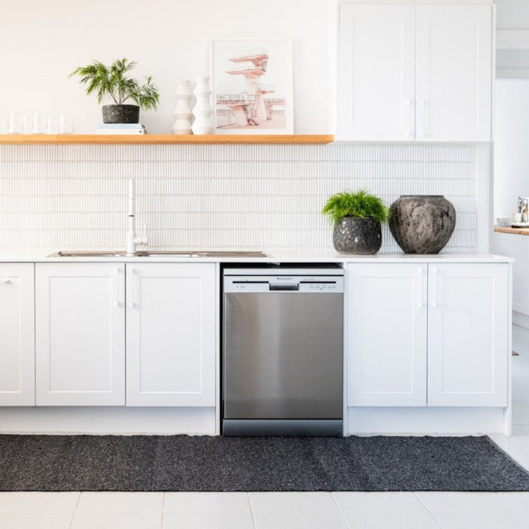 Durable and machine-washable Zebra Home Clements dark grey runner mat placed in a bright, modern kitchen layout.