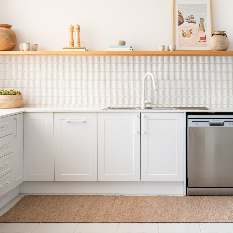 Zebra Home Fraser warm beige machine-washable runner mat placed along a bright, moder kitchen floor layout.