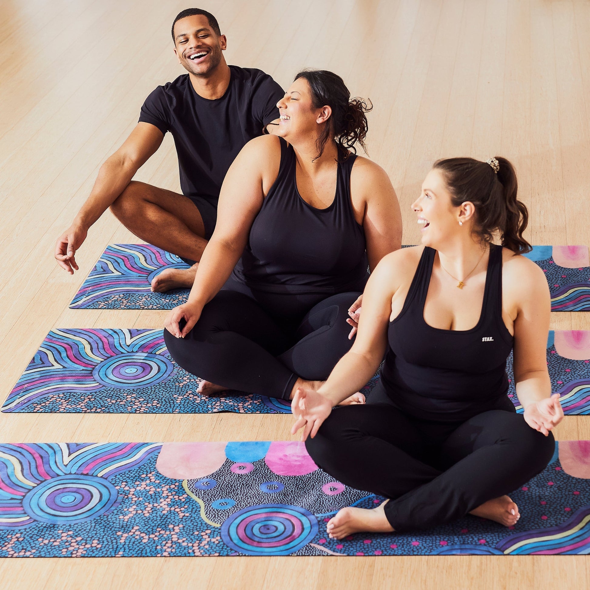 Yoga Mat | Wild Mingo | Oorunye Recycled Rubber & Microsuede Non-Slip unrolled on a studio floor with three people
