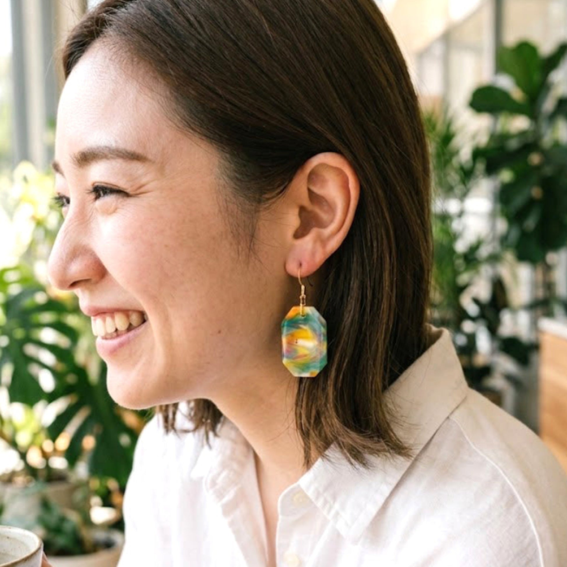 On-model style shot showing the drop length, geometric scale, and visual appeal of the upcycled yellow and green octagon dangle earrings.