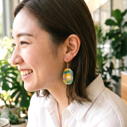 On-model style shot showing the drop length, geometric scale, and visual appeal of the upcycled yellow and green octagon dangle earrings.