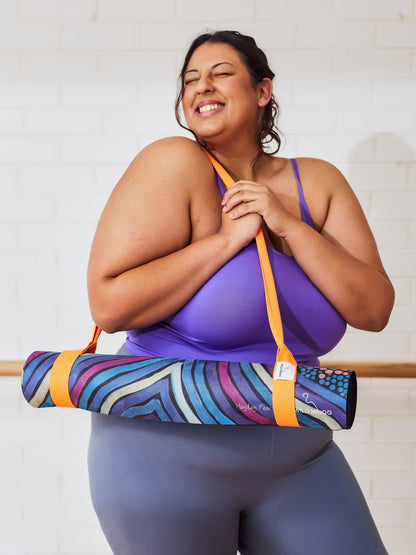 Yoga Mat | Wild Mingo | Oorunye Recycled Rubber & Microsuede Non-Slip rolled with strap over the shoulder of a woman