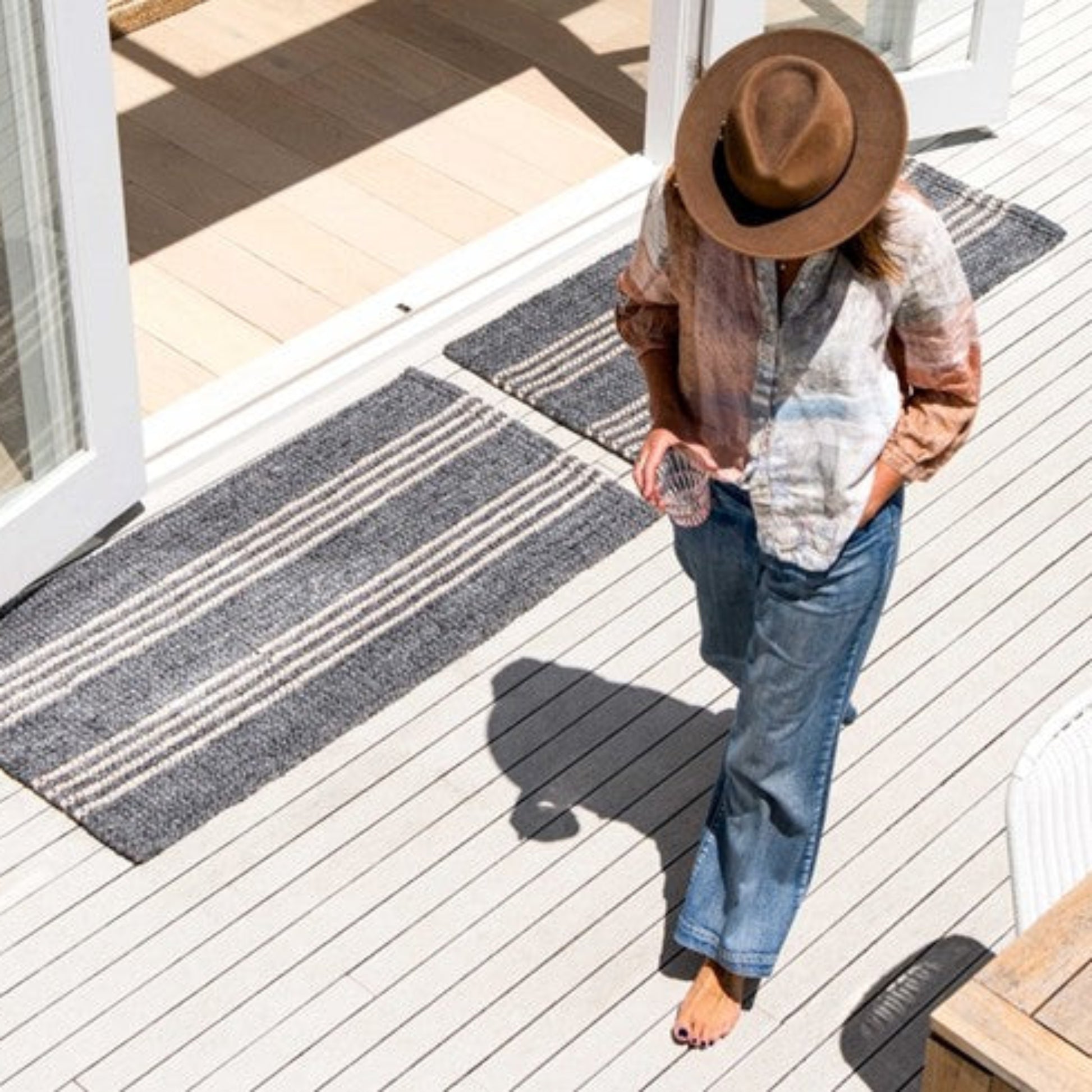 Zebra Home Cornell Lite grey striped indoor outdoor runner and doormat styled on a modern timber deck.